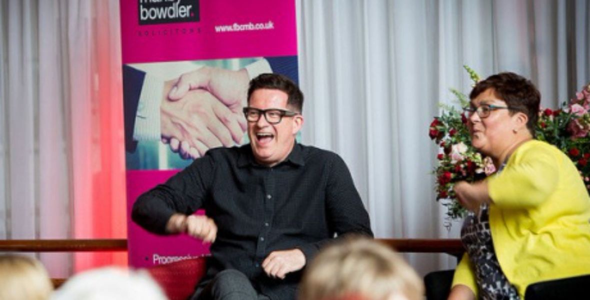 helga henry and matthew bourne, seated and laughing