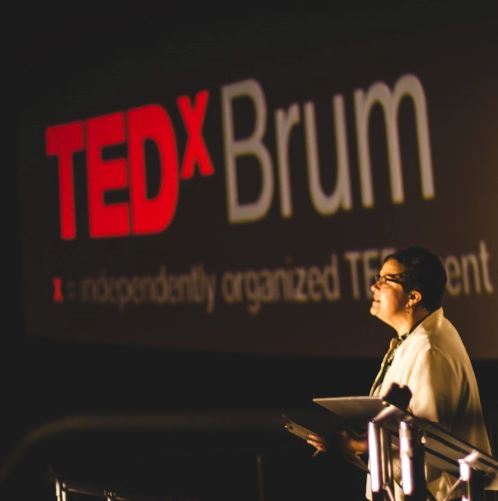 helga henry standing at podium, presenting at ted x brum